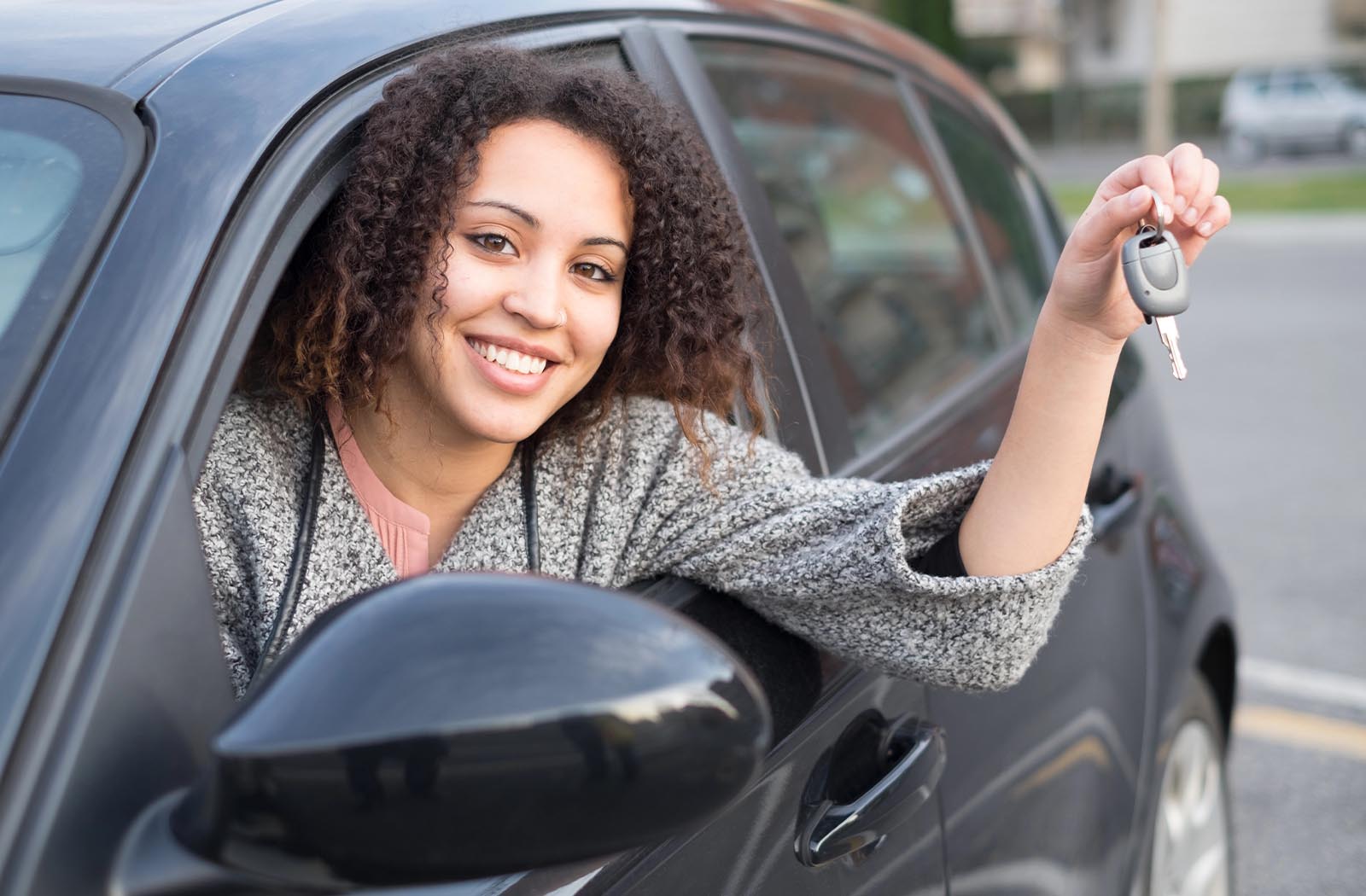 Young woman holding car keys for auto title bond in Spring, TX